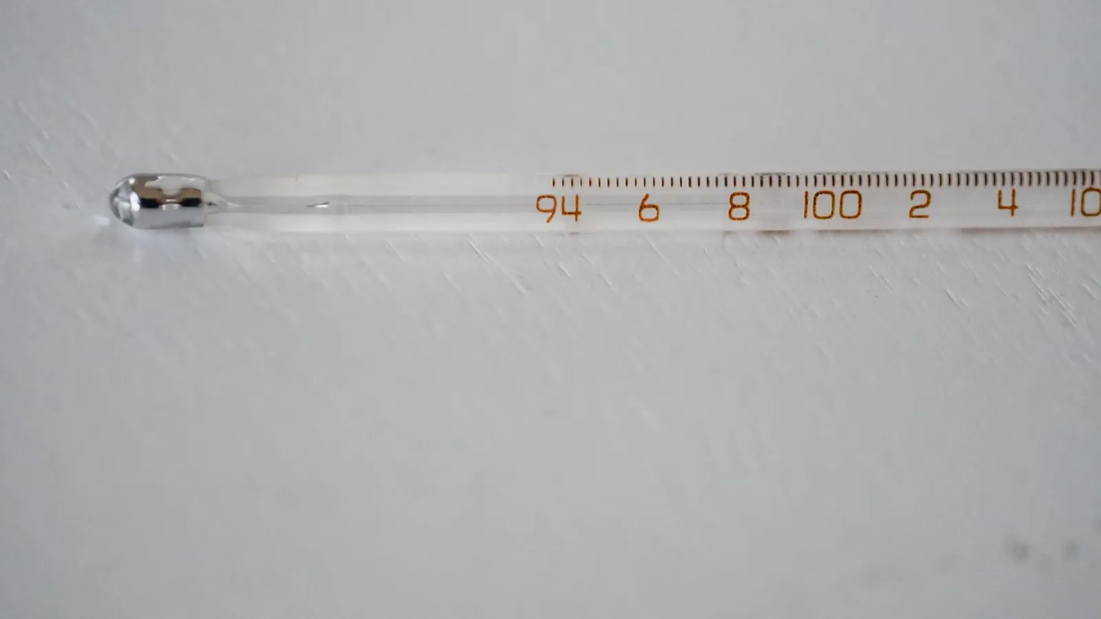 Detailed image of a glass thermometer displaying temperature in degrees.