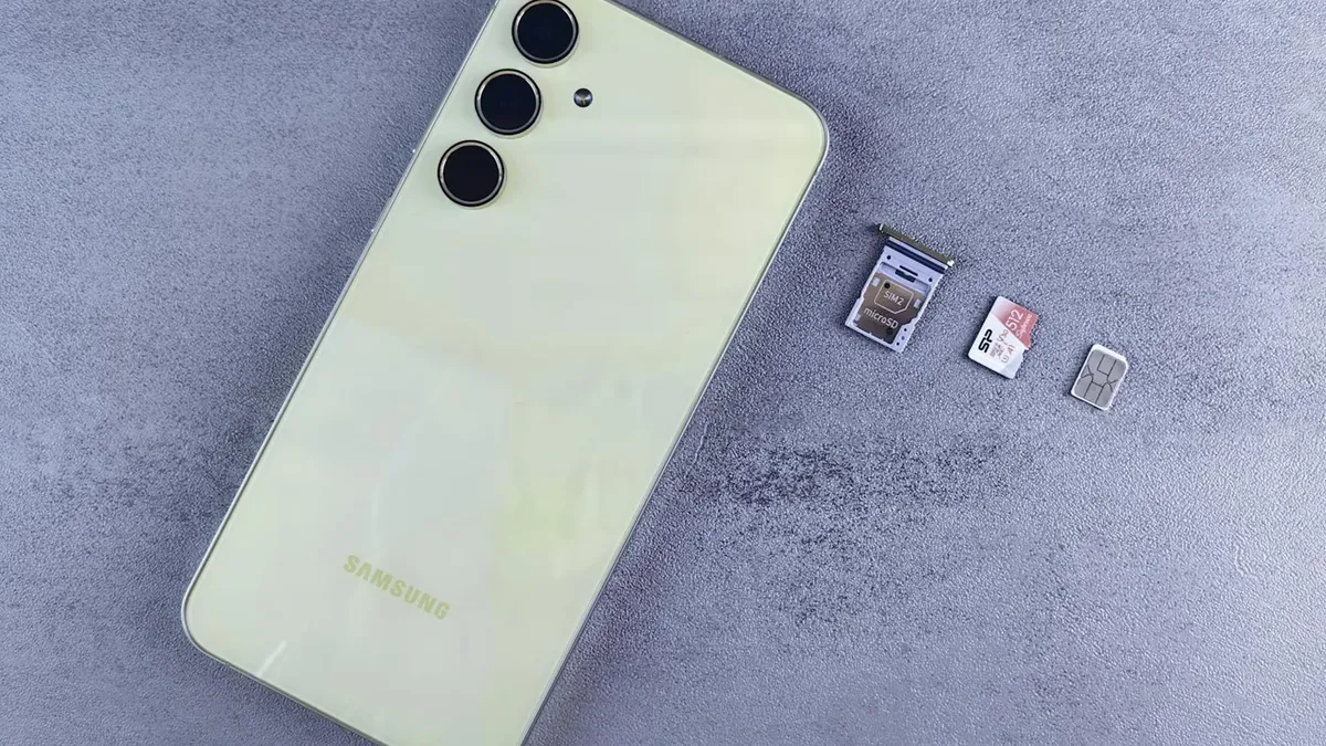Yellow smartphone with SIM tray, memory card, and SIM card on gray background.