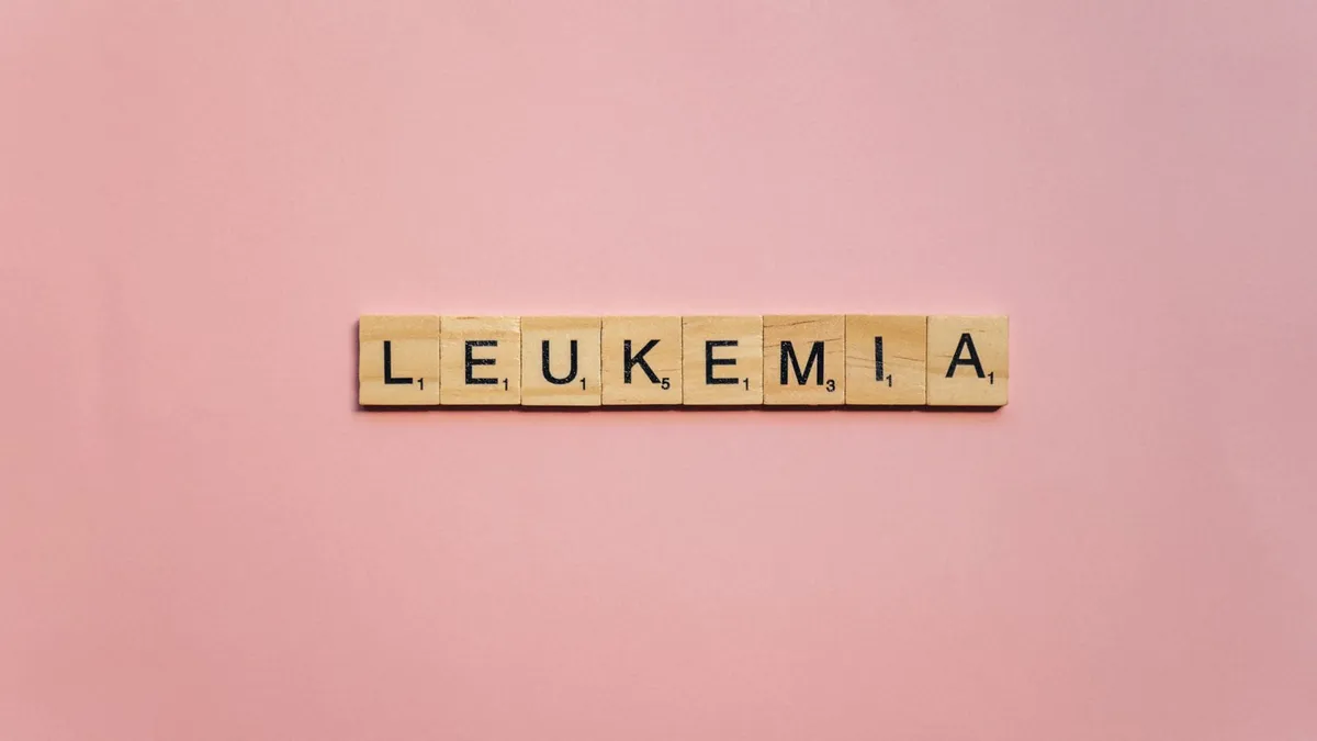 Wooden tiles spelling out 'Leukemia' on a pink background, symbolizing health awareness.