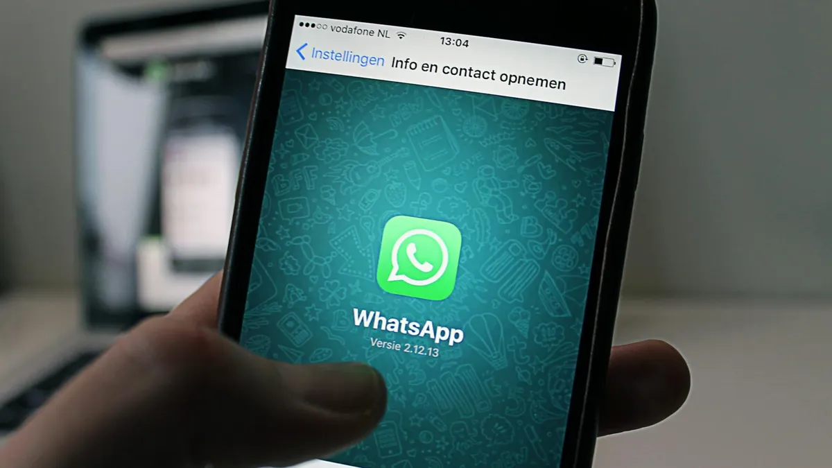A smartphone displaying the WhatsApp application screen held by a person.