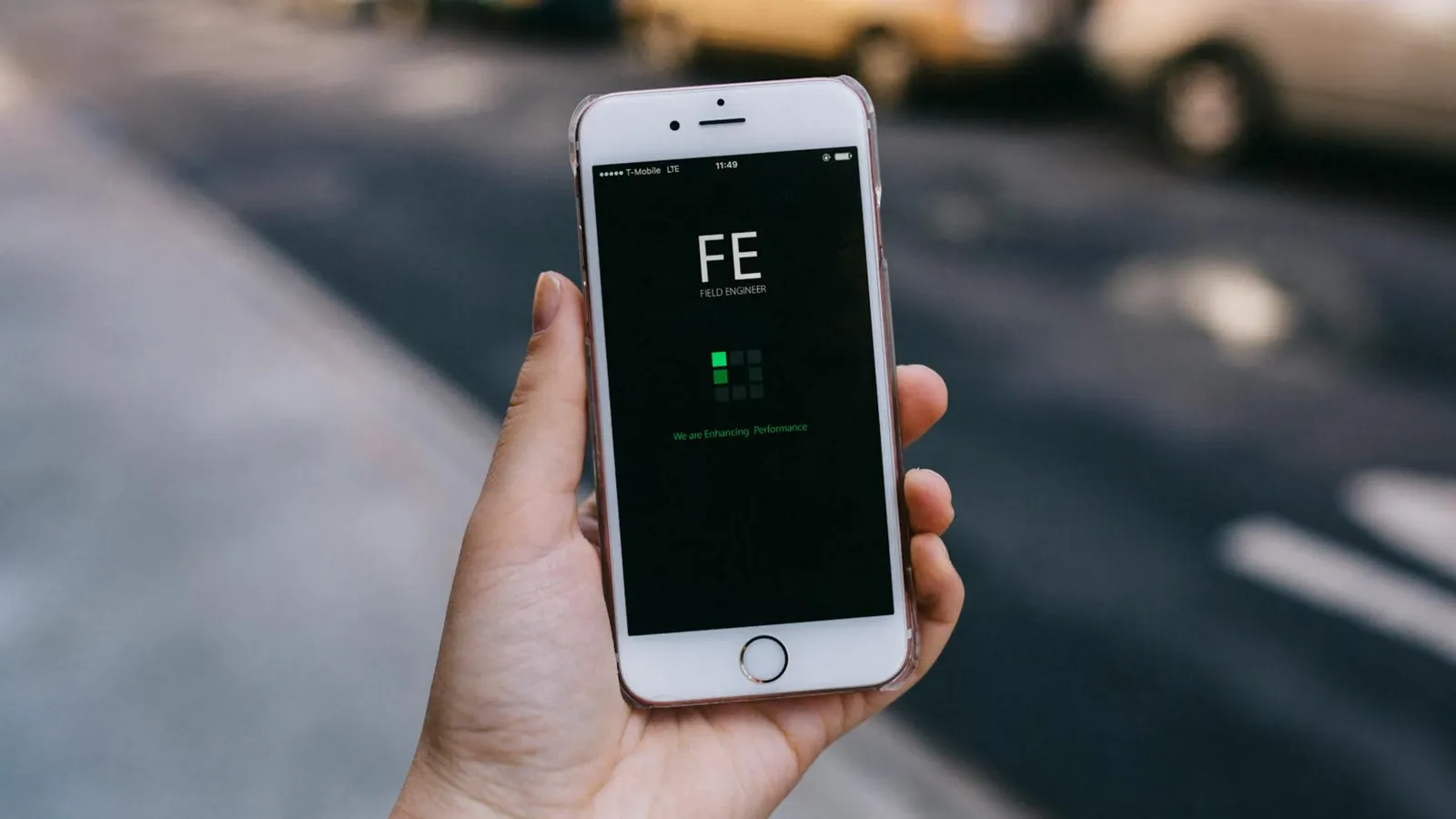 Close-up of a smartphone with an app on screen held by a person in an urban setting.