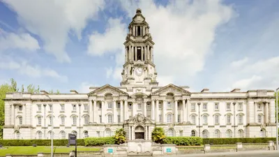 Front view of the iconic Stockport Town Hall with a clear blue sky backdrop.