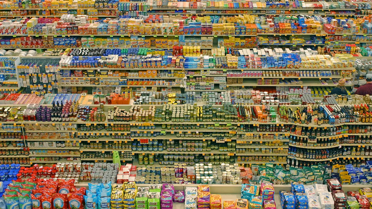A shopping basket with groceries and receipt at a UK supermarket checkout, representing consumer purchases and promotional claims.