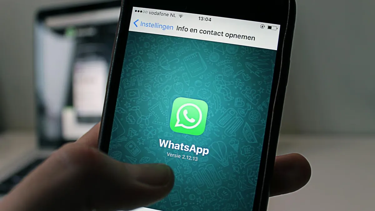 A smartphone displaying the WhatsApp application screen held by a person.
