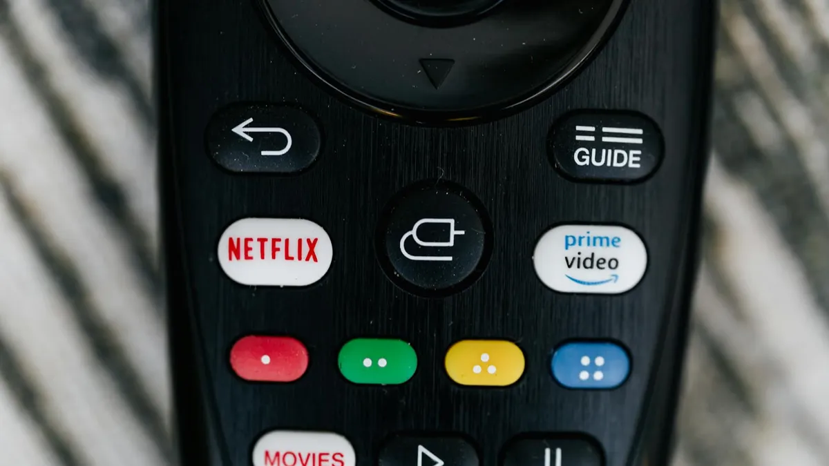 Detailed close-up image of a TV remote control with streaming service buttons.